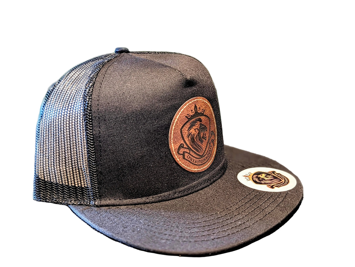 Black mesh cap with leather patch and logo on a textured surface