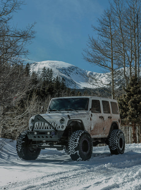 Lifted off-road Jeep SUV with custom grill on snowy mountain trail, LynXautoinnovate automotive parts