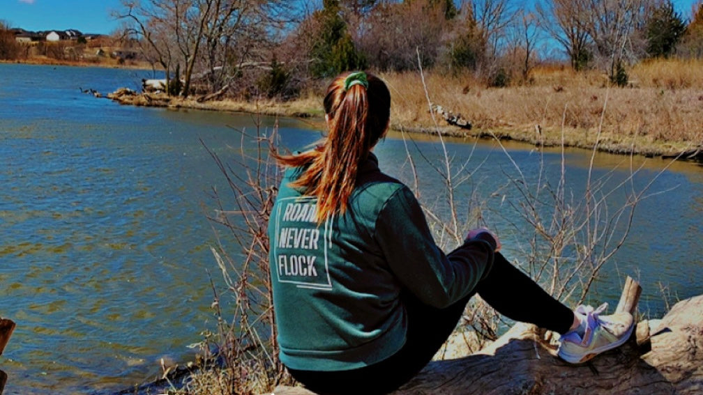 Apparel jacket outdoor wear that reads "roam never flock". 