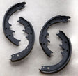 Two black brake shoes on a gray background