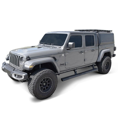 Gray Jeep SUV with a roof rack on a white background