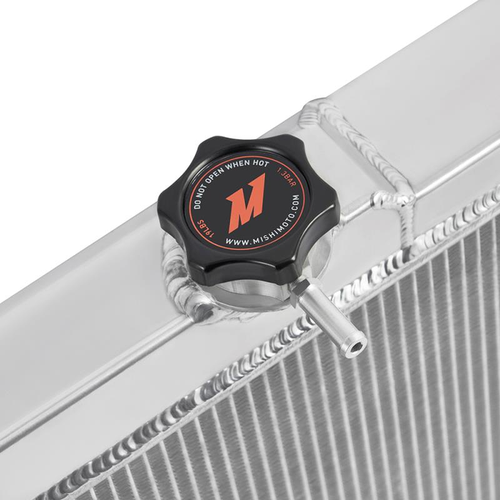 Radiator cap with Mishimoto logo on a radiator. The background is white