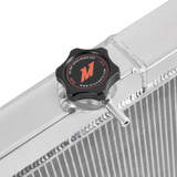 Radiator cap with Mishimoto logo on a radiator. The background is white